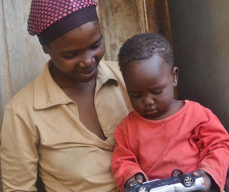 Tanzaniansk kvinne holder barnet sitt