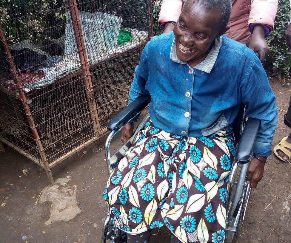 Tanzaniansk kvinne smiler i sin nye rullestol