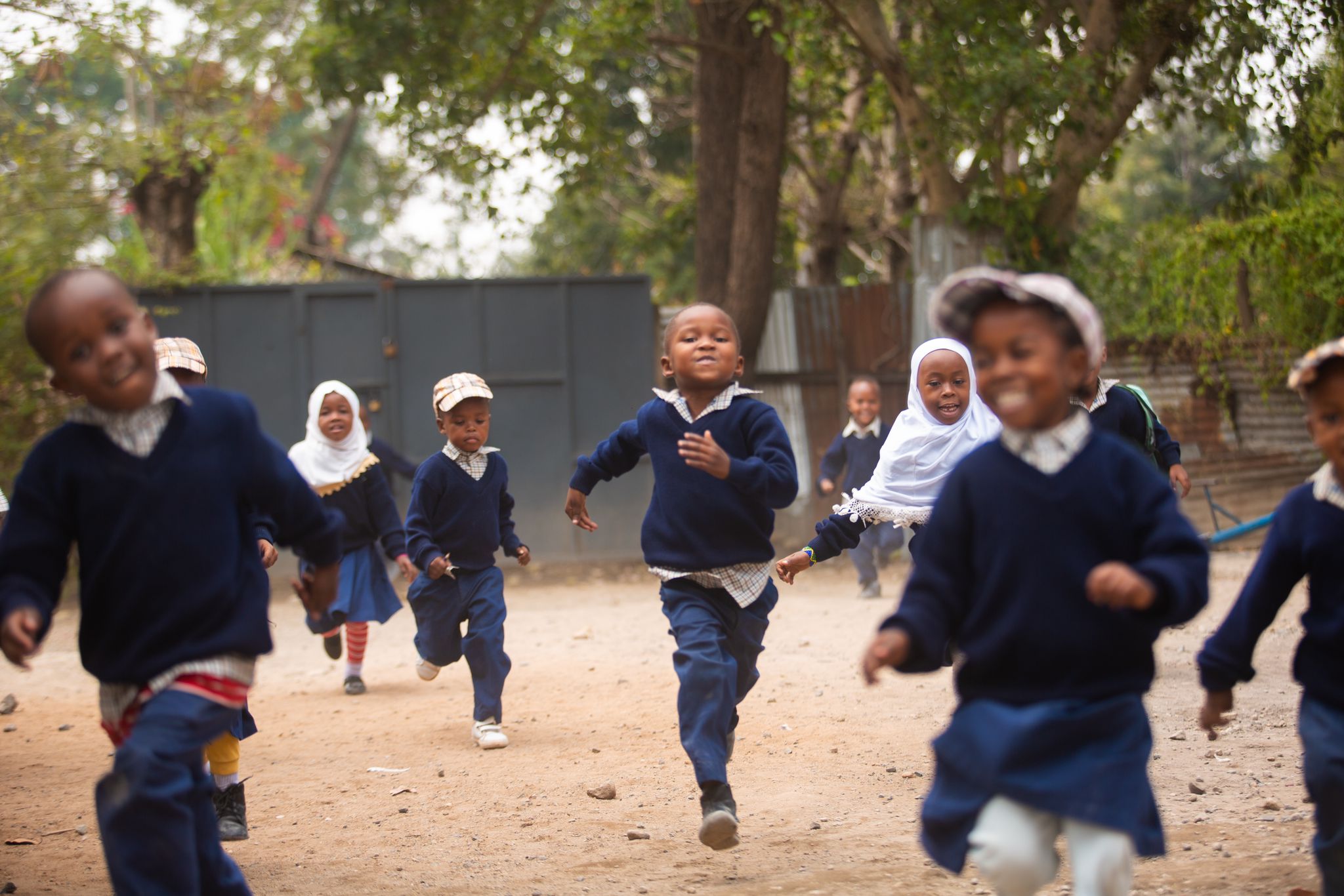 Barn som løper og smiler på en skole i Tanzania