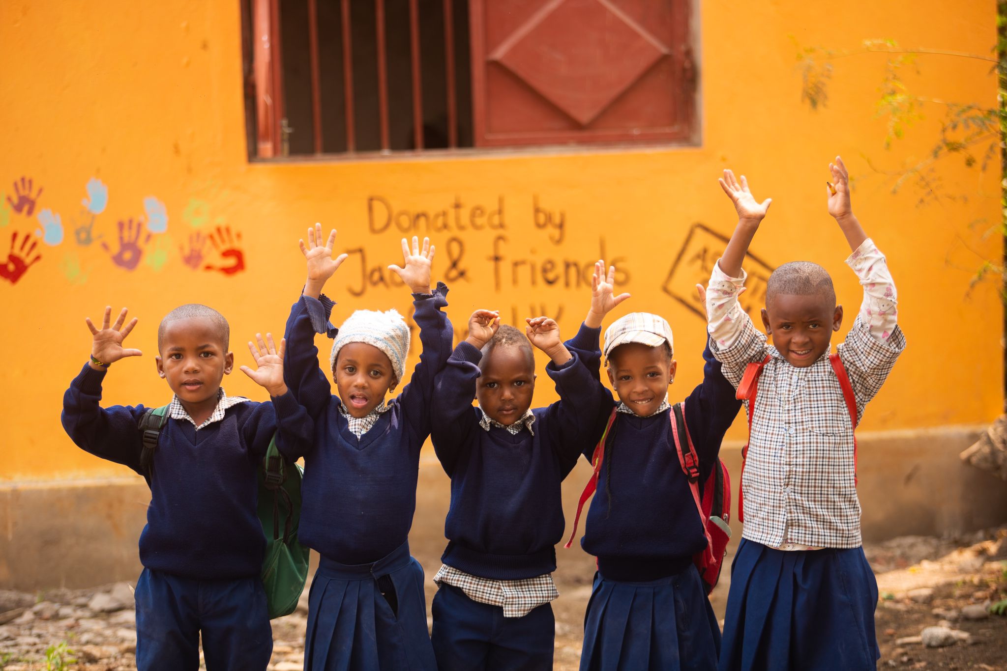 Barn med hendene i været på en skole i Tanzania